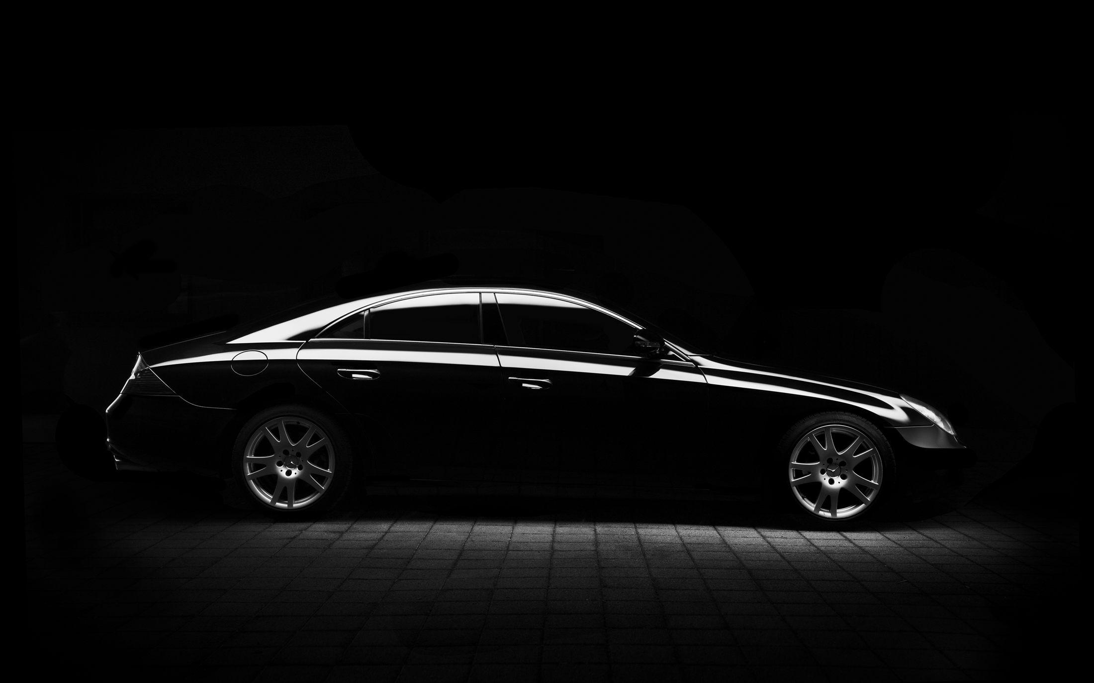 Dark premium car under controlled studio lighting